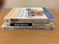 Stack of three baby care books showing spines and partial covers