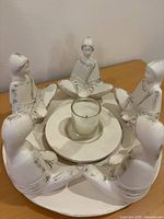 top view of circular candle holder showing six figures and central glass votive