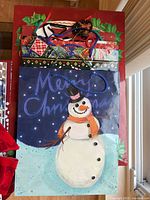 Stack of assorted Christmas gift bags showing snowman design on top