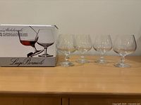 Box and four crystal brandy glasses on tabletop