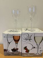 Two boxed sets of Luigi Bormioli Michelangelo wine glasses with one sample glass atop each box