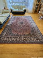 Full view of rectangular wool area rug on hardwood floor