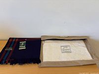 Both shawls folded; Oswal on left, Kashmiri Pashmina in sleeve on right