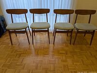Front view of four teak chairs lined up