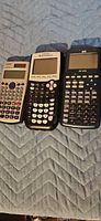 Front view of all three calculators showing displays and keypads