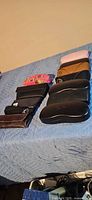 row of approximately nine eyeglass cases on bed