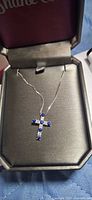 Necklace in open Shane Co box showing sapphire cross pendant on chain
