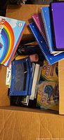 Overview of box showing notebooks, tablet, rainbow kit, pencil pouch and other supplies