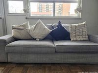 Front view of grey 2-seat sofa with five cushions
