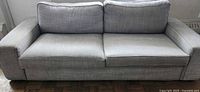 Front view of grey two-seat sofa with back cushions and seat cushions