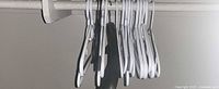 Group of assorted hangers on closet rod