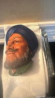 Angled view of Bossons Sikh chalkware head showing side profile and vibrant colours