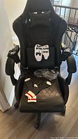 Front view of Dowinx gaming chair showing lumbar cushion, socks on seat, armrests, footrest folded