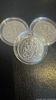 Front view of three 1969 Canadian 50-cent coins in clear capsules, showing Canadian Coat of Arms reverse designs