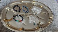 All five bracelets arranged on silver-tone tray