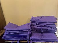 Stacks of purple scrub pants folded on surface