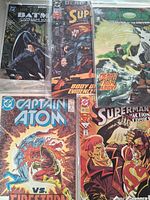 Five bagged DC comic books laid out