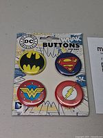 Front of card showing four DC Comics logo buttons