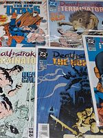 Group of bagged DC comics including Deathstroke the Terminator #26, #42, another issue, and The New Titans cover