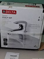 Front of sealed box showing Delta branding, model Spree 532LF-WF, chrome faucet image