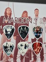 Close-up of upper six guitar picks showing band images