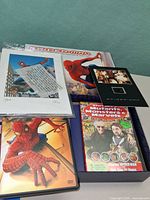 Open gift box showing DVDs, lithograph print, film cell, comic reprint