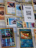 Binder page showing multiple English Trainer cards and two Japanese holo cards