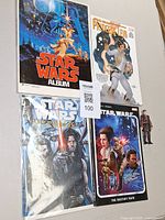 Group shot of four Star Wars publications plus action figure