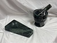 Overall view of green marble ashtray and mortar with pestle