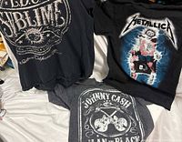 Overview of three band T-shirts laid out