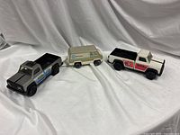 Three Tonka vehicles side by side: Bell System van, blue-stripe pickup, red-stripe pickup