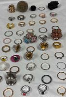 Overhead view of entire assortment of 50 rings laid out on white cloth