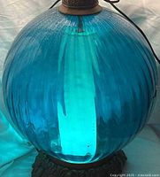 Close view of teal crackled glass globe showing texture and color