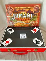 Closed red Fantasma Magic case in front of Jumanji board front panel