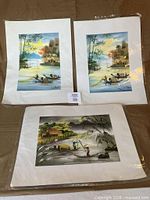 All three signed prints laid out on surface