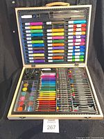 Open wooden art case showing full assortment of drawing and painting materials