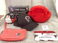 Group shot of all items: Tire Toss box, cap, two plush toys, two wallets