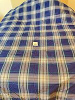 Full view of blue plaid duvet cover spread on bed