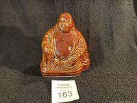 Front view of brown glazed ceramic Buddha figurine