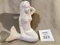 front view of white ceramic mermaid figurine with scale detailing and lot card
