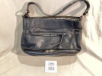 Front view of black leather handbag with zip pocket and logo