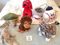 Group of all plush toys and basket on bed