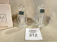 Both crystal shakers with original stickers beside worn box