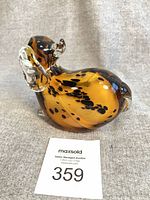 front view of amber and black spotted blown glass puppy figurine with clear accents