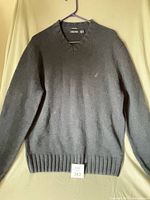 Front view of sweater on hanger showing overall design and logo