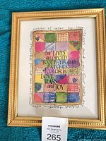 Full view of framed artwork showing quote and patchwork design