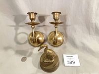 Pair of brass wall sconces and brass stork figurine with scale coin