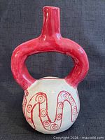 Front view of glazed stirrup spout vessel showing serpent motif and red handle