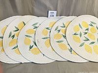 six round woven lemon print placemats displayed side-by-side