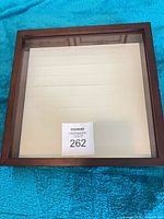Front view of square wooden shadow box with glass front